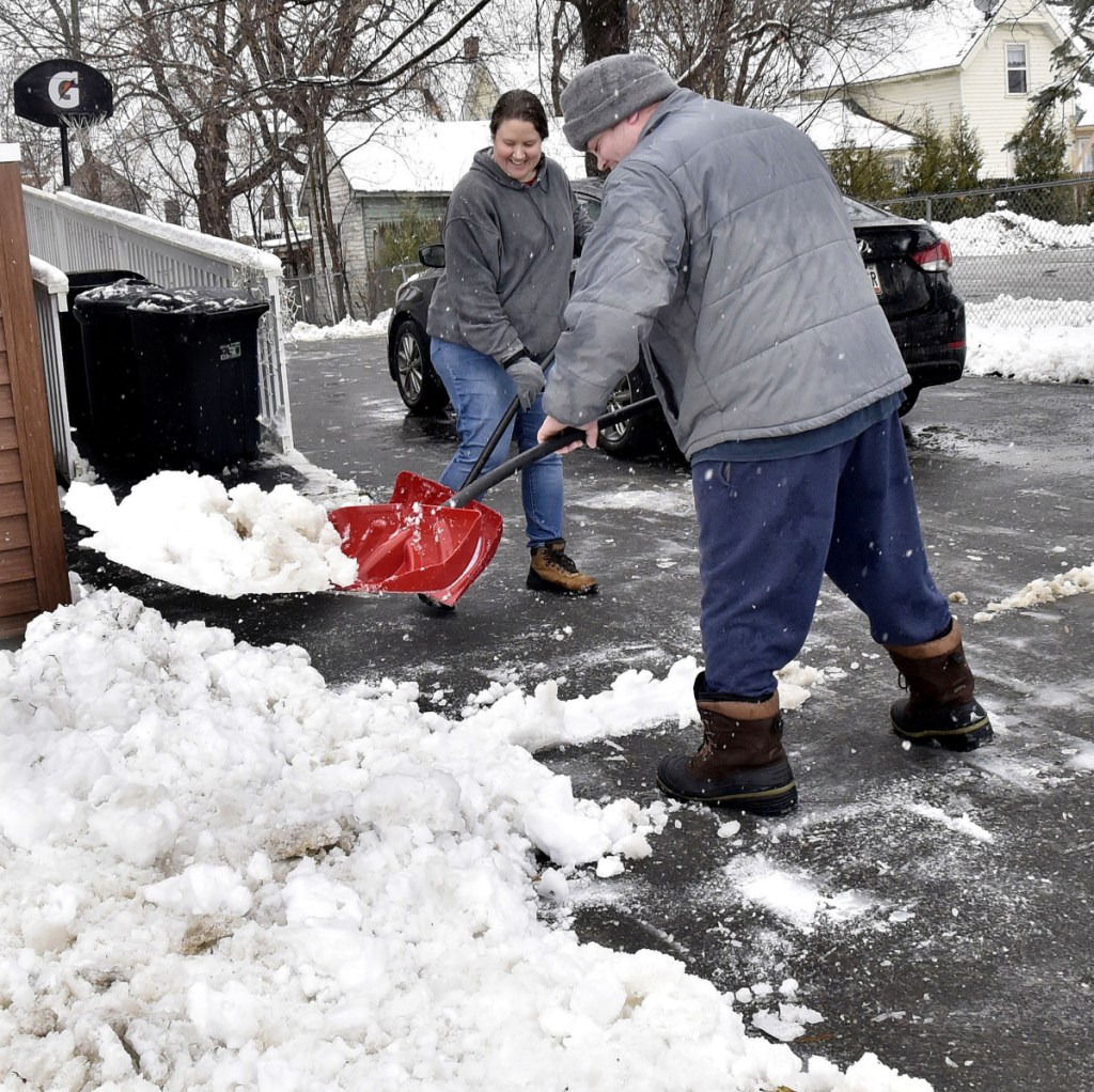 Amanda and William Carlton teamed up to shovel snow from driveway at their home in Waterville during a snowstorm on Tuesday.