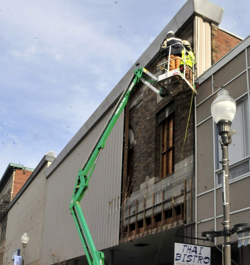 Workers remove the exterior facade covering the former Atkins building on Main Street in downtown Waterville in January. The Central Maine Growth Council is offering grants to make improvements to building facades in downtown Waterville.