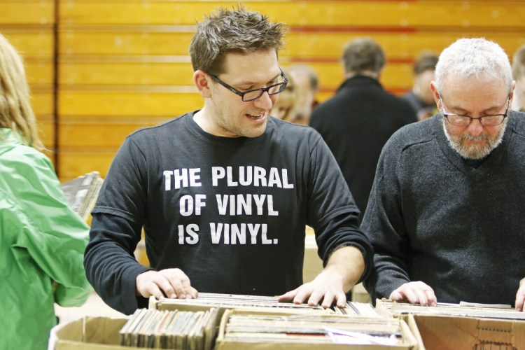 Hundreds of vinyl enthusiasts, including Brian Lozo of Biddeford and Jonathan Gilbert of Portland seek out hidden gems Saturday at the WMPG Record Sale at the University of Southern Maine's Sullivan gym. 