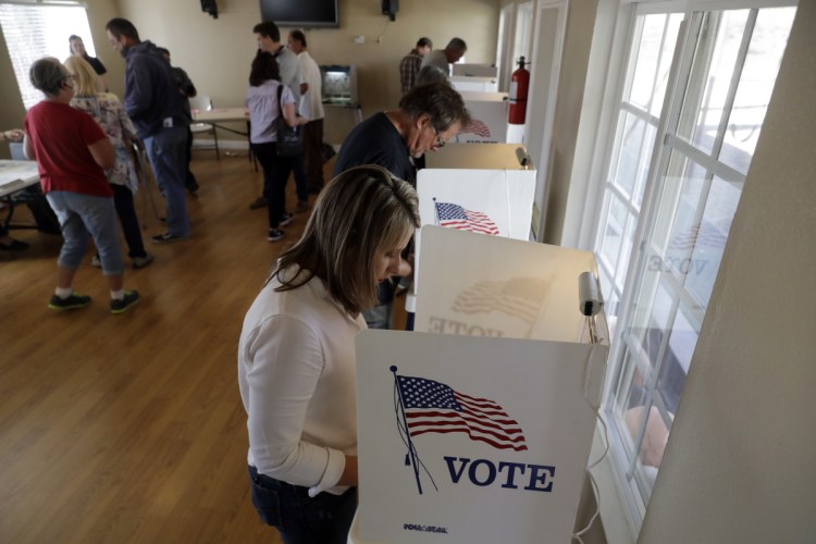 Katie Hill, bottom right, a Democratic Party candidate from California's 25th congressional district, votes Tuesday in Agua Dulce, Calif. Hill is running against Republican incumbent Steve Knight. The fight for control of the House could come down to a handful of seats, particularly in California.