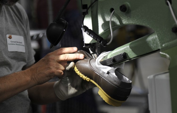 An L.L. Bean employee trims a boot being produced in the company's Lewiston plant. Sales of Bean boots continue to be strong, company CEO Steve Smith says.