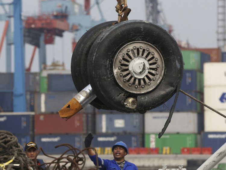 A crane moves two wheels recovered from the Lion Air jet that crashed into the Java Sea on Oct. 29 for further investigation in Jakarta, Indonesia.