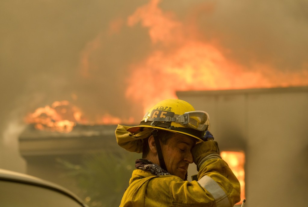 A firefighter battles the heat near a residence in Malibu, Calif., on Friday. The cause of the 140-square-mile blaze is not yet known.