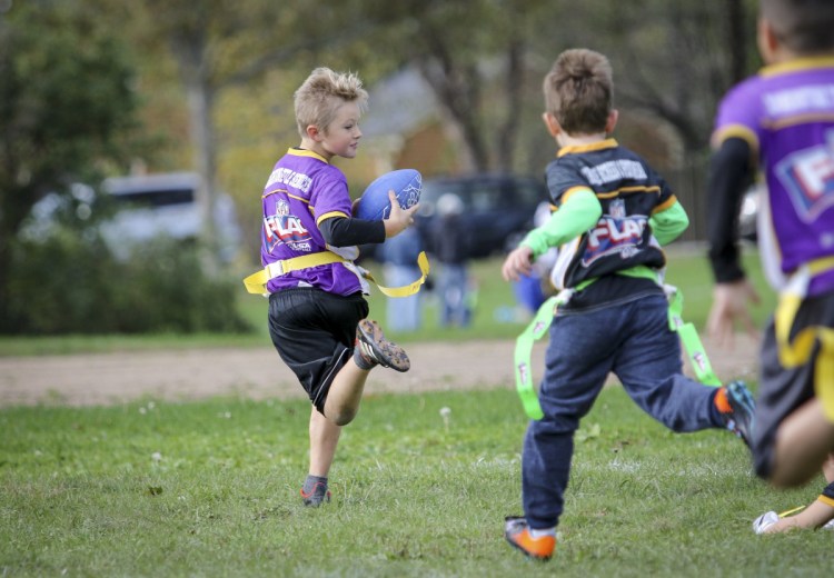 Mateo Pulaski, left, runs for the end zone before realizing he lost a flag during a flag football game in Portland. 