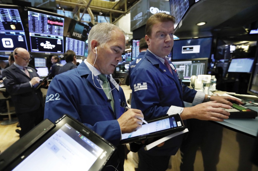 Timothy Nick, center, works with specialist Michael O'Mara on the floor of the New York Stock Exchange this month.