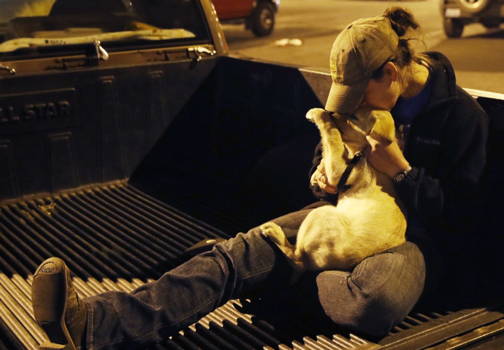 Sarah Gronseth kisses her dog Tuesday in Chico Calif. The teacher, who helped evacuate high school students, lost her Paradise home in the fire. Local governments should look at their decisions to allow subdivisions in places with high fire risks, an expert on building codes says.