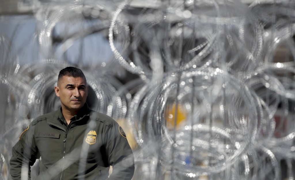 A U.S. Border Patrol agent looks through concertina wire during a tour of the San Ysidro port of entry on Friday in San Diego.