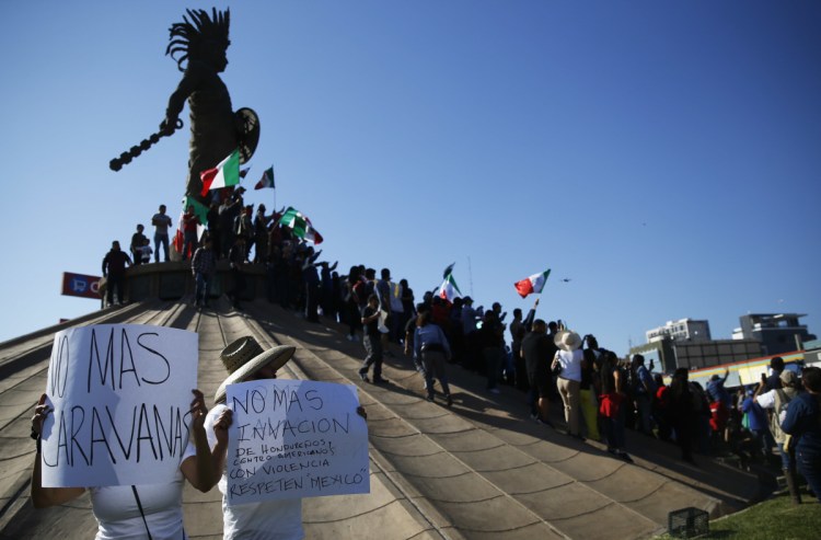 Protesters gather at a statue of Aztec ruler Cuauhtemoc in Tijuana, Mexico, to urge thousands of Central American migrants to return to their countries.