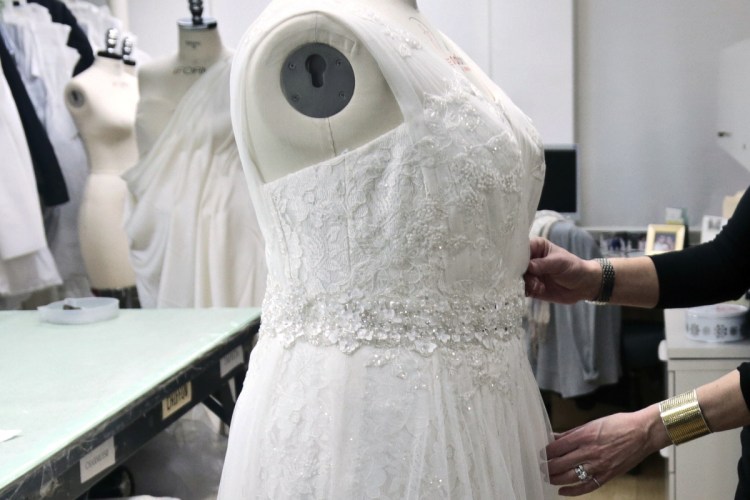 A David's Bridal employee arranges a dress on a mannequin in New York in this 2013 photo. David's Bridal is filing for bankruptcy protection but there is no danger for customers who have ordered dresses because operations will continue while the wedding and prom retailer restructures, the company says.