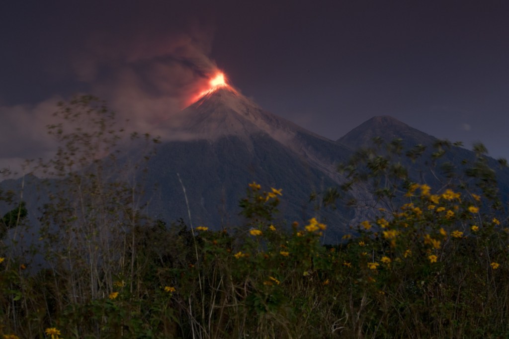The Volcan de Fuego, or Volcano of Fire, spews hot molten lava from its crater in Escuintla, Guatemala, early Monday. Disaster coordination authorities have asked several communities to evacuate and go to safe areas after its second eruption in six months. (AP Photo/Moises Castillo)