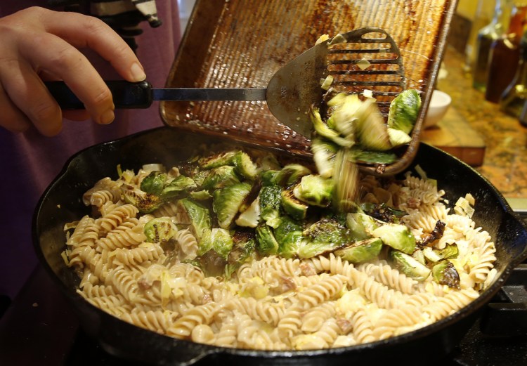 Roasted and quartered Brussels sprouts are tipped into a skillet containing a mixture of rotini, chorizo, leeks, garlic and cream.