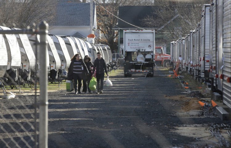 Sonia Geha, left, and her mother Laila Eid, second from left, both of Lawrence, Mass., carry belongings as they depart a trailer camp for people displaced by gas line failures and explosions on Sept. 13. Families in Massachusetts' Merrimack Valley are facing a challenging Thanksgiving following September's natural gas explosions and fires.