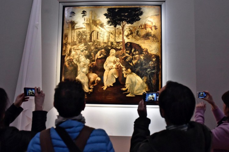 Visitors take pictures of Leonardo da Vinci's "Adoration of the Three Wise Men" in the Uffizi museum in Florence, Italy. A 2017 arrangement to send Leonardo works to France for a blockbuster exhibit next year, the 500th anniversary of his death, has Italy's nationalist-leaning government up in arms.