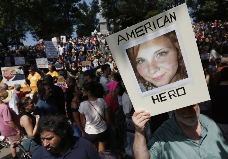A counter-protester holds a photo of Heather Heyer on Boston Common at a "Free Speech" rally organized by conservative activists, in Boston. Jury selection is set to begin in the trial of James Alex Fields Jr., accused of killing Heyer during a white nationalist rally in Charlottesville in 2017.