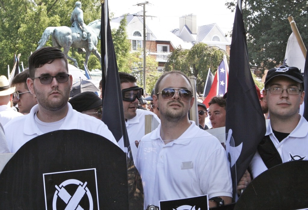 James Alex Fields Jr., left, holds a black shield in Charlottesville, Va., where a white supremacist rally took place. Fields Jr., of Maumee, Ohio, is charged with first-degree murder for allegedly driving his car into a crowd of people protesting against white nationalists.