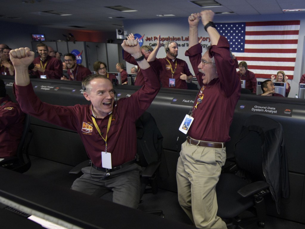 Mars InSight team members Kris Bruvold, left, and Sandy Krasner rejoice Monday inside the Mission Support Area at NASA's Jet Propulsion Laboratory in Pasadena, California, after receiving confirmation that the Mars InSight lander successfully touched down on the surface of Mars.