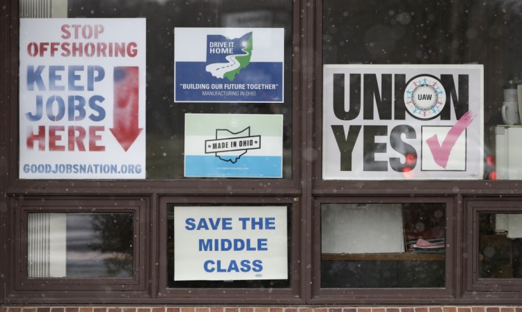 Signs hang in windows at the UAW Local 1112 union hall Tuesday in Lordstown, Ohio. Even though unemployment is low, the economy is growing and U.S. auto sales are near historic highs, GM is cutting thousands of jobs in a major restructuring aimed at generating cash to spend on innovation. GM put five plants up for possible closure, including the plant in Lordstown.