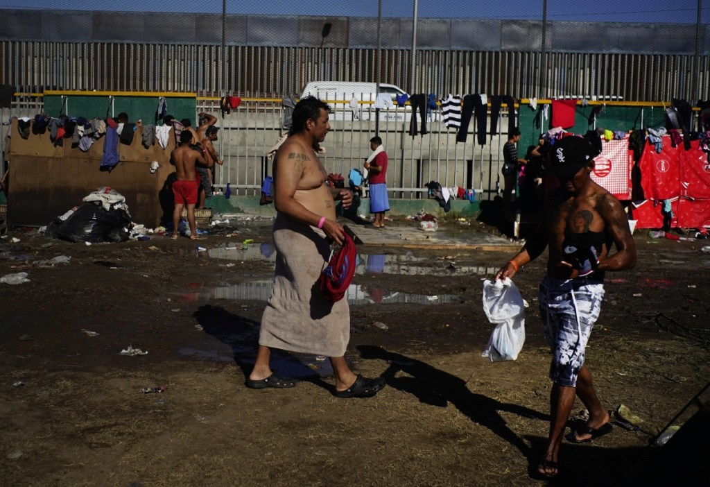 People who are part of the migrant caravan bathe at the Benito Juarez Sports Center, which is serving as a temporary shelter, in Tijuana, Mexico, on Tuesday.