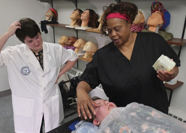 Funeral services students Maeve Curran, left, and Anita Bennett start to build a life mask on a State University of New York at Canton classmate. Eighty percent of the undergrad funeral director students at the school are female, mirroring a nationwide trend.