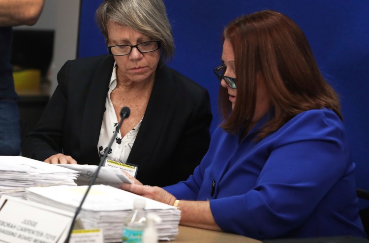 Canvassing Board members, Judge Betsy Benson, left, and Judge Deborah Carpenter-Toye look over signatures on ballots at the Broward County Supervisor of Elections in Lauderhill, Fla., Thursday, November 8, 2018. 