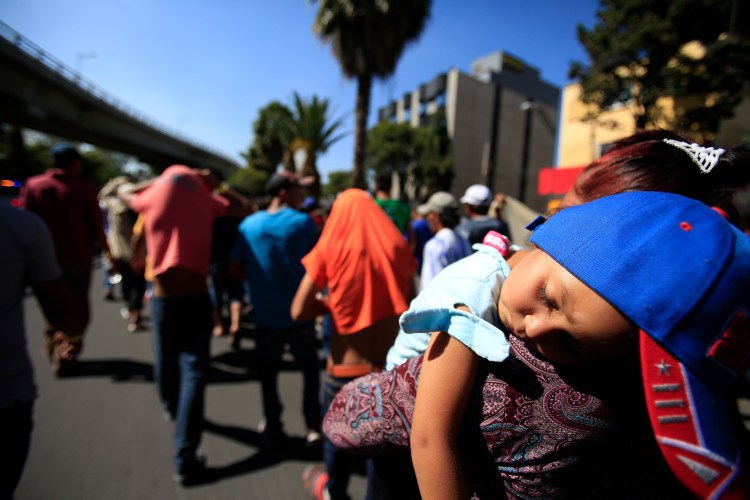 A sleeping Honduran girl is carried as a group of Central American migrants, representing the thousands participating in a caravan trying to reach the U.S. border, undertake an hours-long march to the office of the United Nations' humans rights body in Mexico City, Thursday. 