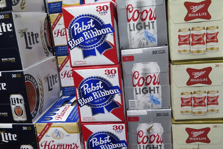 In this Nov. 8, 2018, file photo, cases of Pabst Blue Ribbon and Coors Light are stacked next to each other in a Milwaukee liquor store. MillerCoors and Pabst Brewing Co. settled a lawsuit Wednesday, Nov. 28, in which the hipster’s brand of choice claimed the bigger brewer lied about its ability to continue brewing Pabst's beers to put that company out of business. 