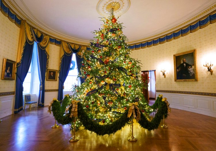 The official White House Christmas tree is seen in the Blue Room during the Christmas press preview at the White House in Washington, Monday. The tree measures 18 feet tall and is dressed in over 500 feet of blue velvet ribbon embroidered in gold with each State and territory.  
