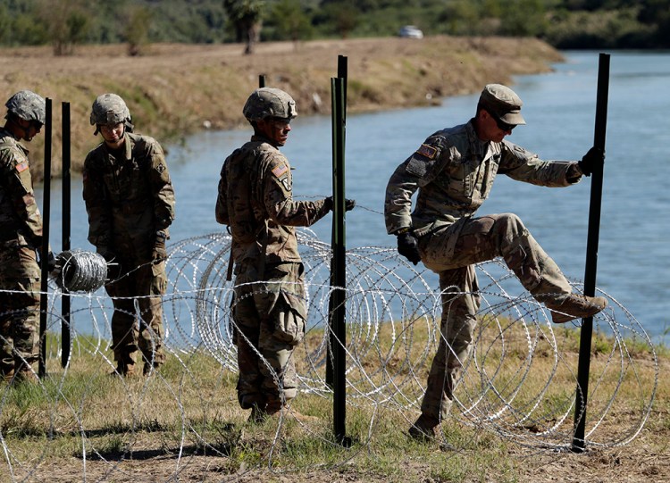 Members of the U.S. military install multiple tiers of concertina wire along the banks of the Rio Grande near the Juarez-Lincoln Bridge at the U.S.-Mexico border in Texas on Friday.