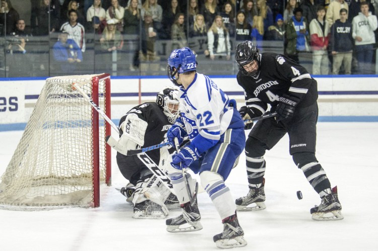 Colby College's Nick O'Connor (22) looks to score on Bowdoin College goalie Erik Wurman (35) as Bowdoin's 	Collin Van der Veen (4) tries to defend  at Colby College in Waterville on Saturday.