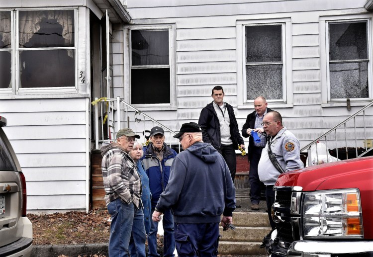 Senior Fire Investigator Ken MacMaster, center, of the state Fire Marshal's Office, speaks with duplex owner Roland Hallee, left, outside his duplex at 34 Green St. in Waterville on Monday. Other investigators and Waterville Fire Capt. John Gromek, right, were at the scene to determine the cause of the fire that occurred late Saturday evening.