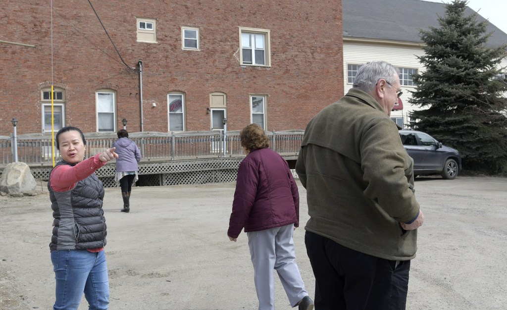 Annie Huang, left, directs customers into her Hallowell restaurant, Lucky Garden, on April 2 during construction on Water Street, which also is U.S. Route 201.