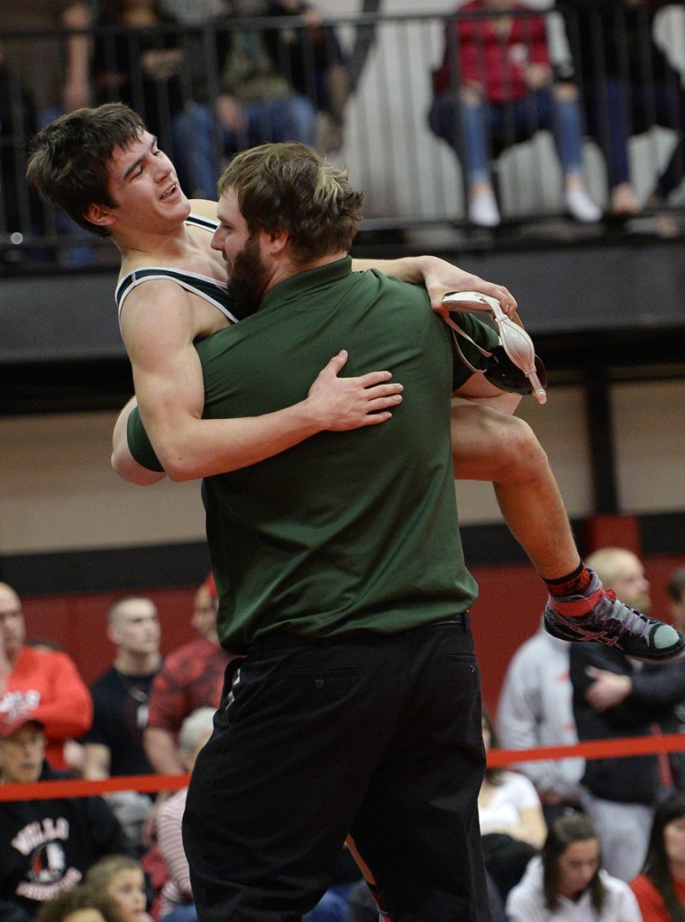 Mount View's Mark Ward is hoisted up by assistant coach Chris Cole after Ward prevailed in a 138-pound match during the Class B championships last season at Wells High School.
