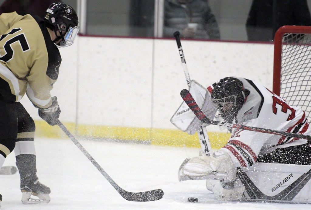 The Kings' Austin Taylor  can't move the puck past the Hawks' Will Hays during a game Monday in Readfield.