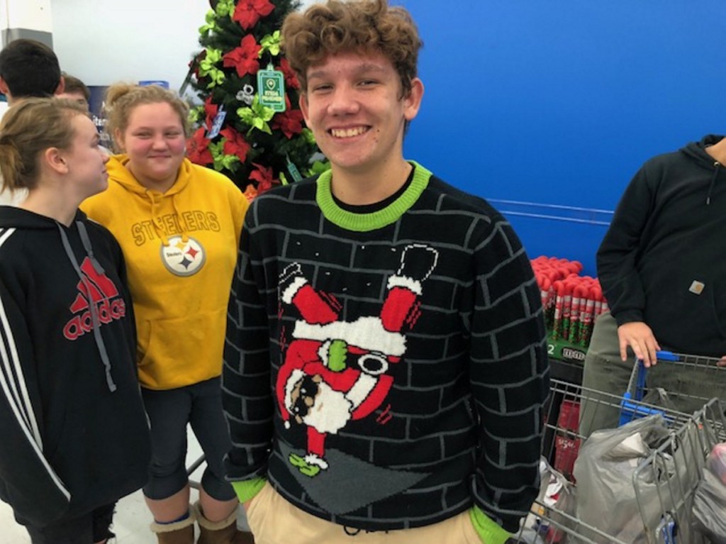 Madison Area High School sophomore Christian Cabrera sports an ugly sweater of Santa Claus break dancing during a shopping spree Wednesday at the Skowhegan Walmart. Students from four area high schools were Christmas shopping for needy children with Jobs For Maine Graduates.