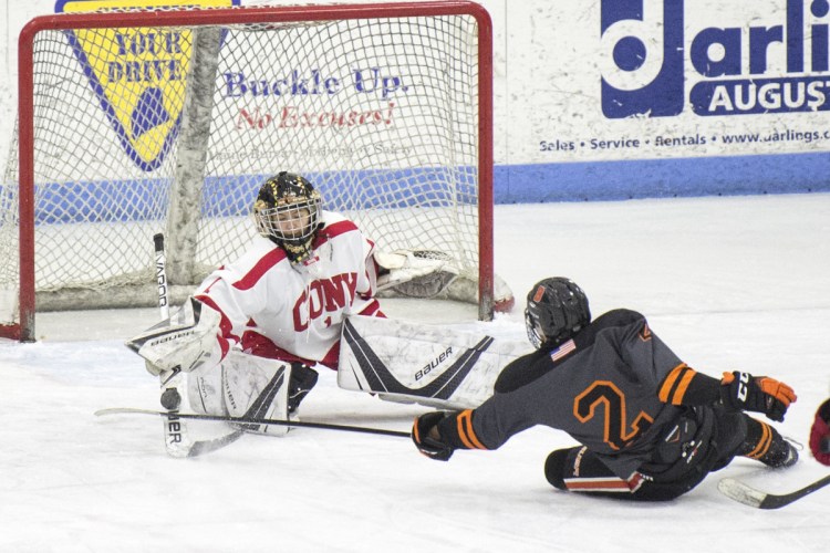Cony goalie Matty Shea makes a save on a shot by Brunswick's Nick Levesque on Saturday at the Camden Nation Bank Ice Vault in Hallowell.