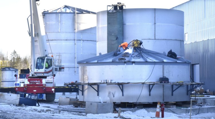 Workers weld one of the anaerobic digesting system tanks beside the Fiberight Corp. solid waste processing and recycling facility under construction in Hampden on Thursday.
