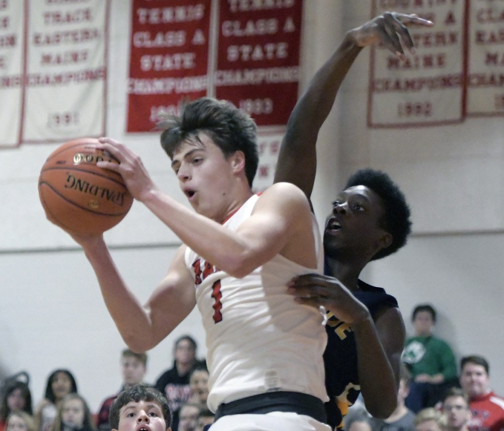 Cony's Ian Bowers grabs a rebound in front of Mt. Blue's Ryan Keaten during a Kennebec Valley Athletic Conference Class A game Thursday in Augusta.