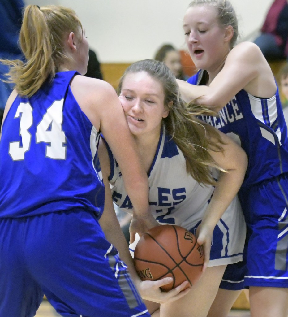 Erskine's Emily Clark, center, gets sandwiched by Lawrence's Sarah Poli, left, and Keagan Alley during a Kennebec Valley Athletic Conference game Friday in South China.