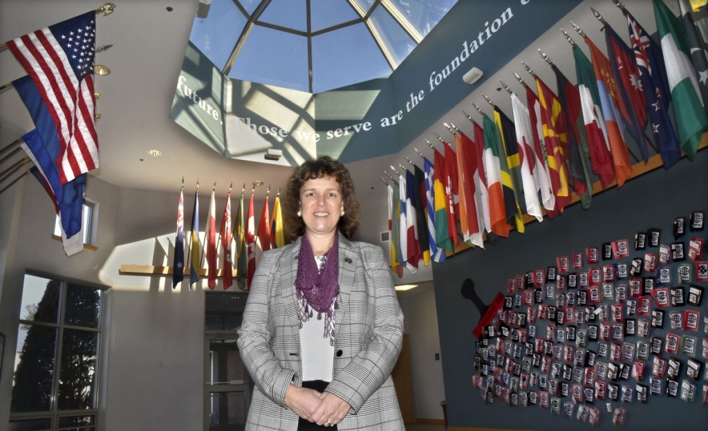 Thomas College President Laurie Lachance stands recently in the Hall of Flags lobby, where the flags of the countries of students attending the Waterville college are displayed. The college is working to grow the number of students attending the school from 772 to 1,000.