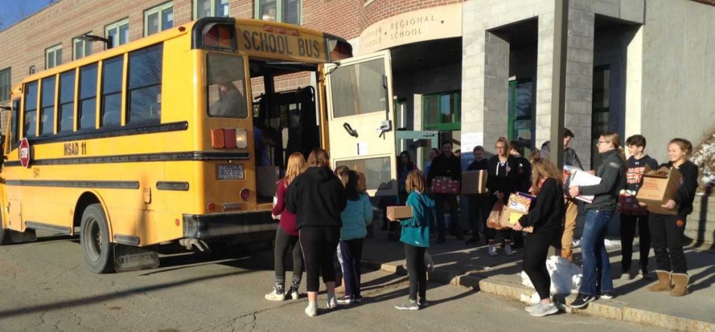 Gardiner Regional Middle School students and staff load a school bus full of food  items for the Chrysalis Place Food Pantry in Gardiner.