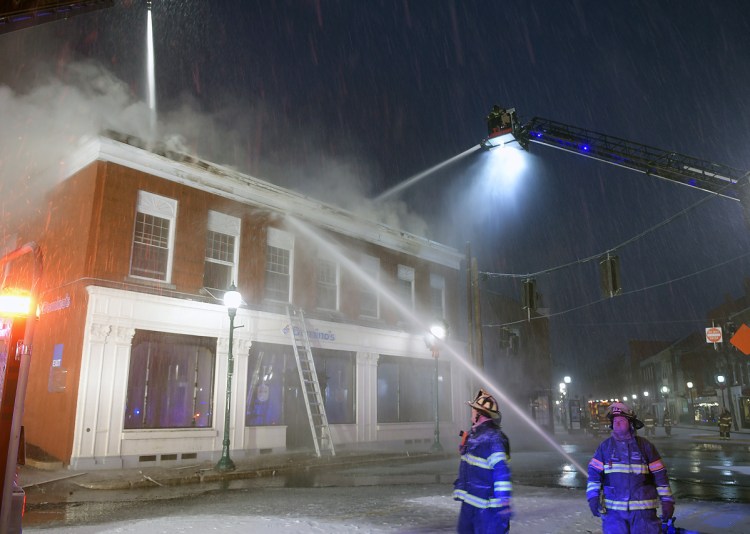 Dozens of firefighters struggle Friday to contain a fire at a building in downtown Gardiner. The blaze was reported just after 3 a.m. at the former bank building at the corner of Church and Water Street.