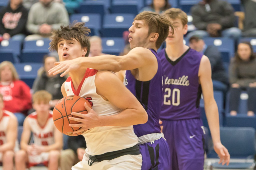 Cony's Ian Bowers tries to take a shot at the basket while Waterville's Nick Wildhaber defends him during the Captial City Hoop Classic on Saturday at the Augusta Civic Center.