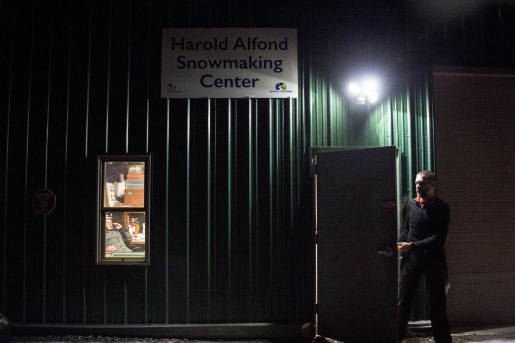 WATERVILLE, ME - DECEMBER 30, 2018 
 Dave MacLeay, president of the board of the Friends of Quarry Road, exits the Harold Aflond Snowmaking Center at Quarry Road late Saturday night after a failed attempt to make snow in Waterville on Sunday, Dec. 30, 2018. Donovan talks on the phone as seen through the window with snowmaking volunteer crews to stay home for the night. The compressor on lease that pumps the water to the snow guns wouldn't start and is on hold for operation until  Sunday morning which means snowmaing operations will have to be rescheduled, weather conditions permitting.(Morning Sentinel photo by Michael G. Seamans/Staff Photographer)