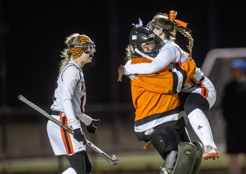 Gardiner's Jillian Bisson, right, jumps into the arms of goalie Lindsey Bell after they defeated Winslow in the Class B North championship game this fall in Waterville.