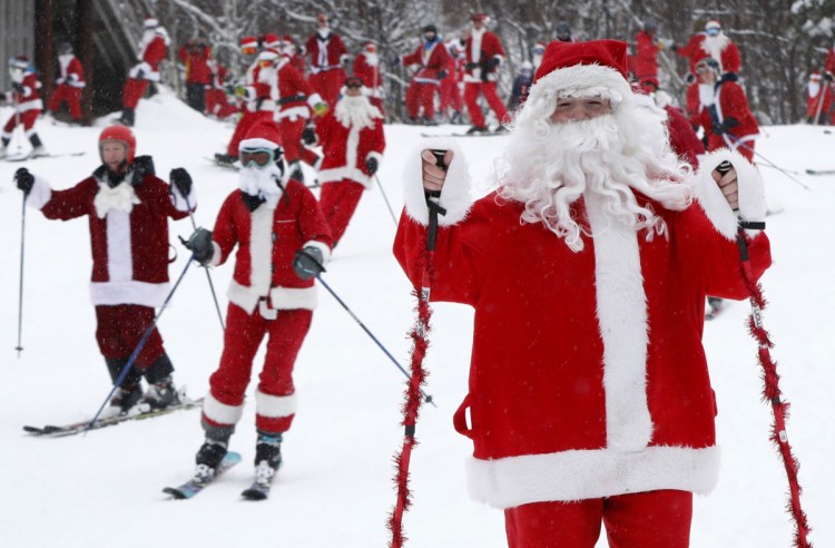 Skiers and snowboarders dressed as Santa Claus head downhill during the annual Santa Sunday event in Newry. The red-suited lookalikes aim to put a smile on people's faces while raising money for charity. Associated Press/Robert F. Bukaty