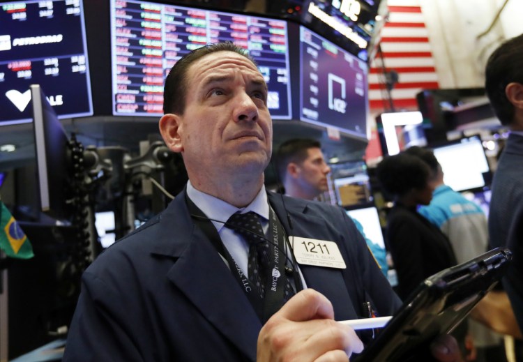 Tommy Kalikas works on the New York Stock Exchange floor Thursday. Signs that the Federal Reserve may back off raising interest rates helped propel stocks back up.