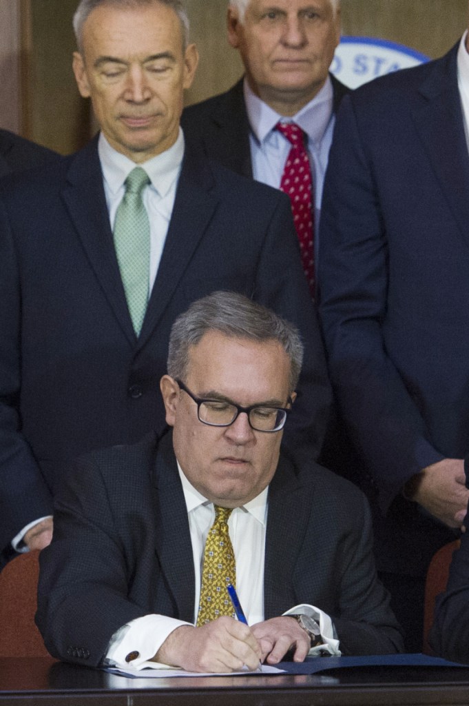 Acting EPA Administrator Andrew Wheeler signs an order lifting federal protection for waterways and wetlands on Tuesday.