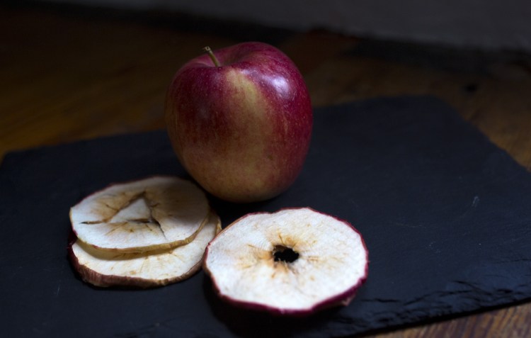A fresh apple and dried apple slices from Applewald Farm stall in the Brunswick Winter Market. The flavor of dried fruit is concentrated, so only a small amount is required to get the desired result in a recipe.