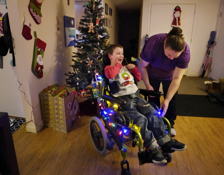 Megan Bouchard turns on lights that decorate her son Trey's wheelchair in their Freeport apartment. Bouchard is a single mother raising Trey, who has cerebral palsy and hydrocephalus, while working as a certified nursing assistant.