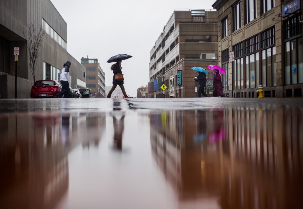 Pedestrians cross at Congress and Elm streets in Portland on Friday. Saturday will be cool and and breezy. Page B6